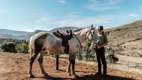 A rider preparing a horse before heading out