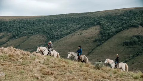 Riders descending into the mountain valley
