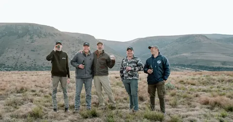 Hunters standing together in the open country